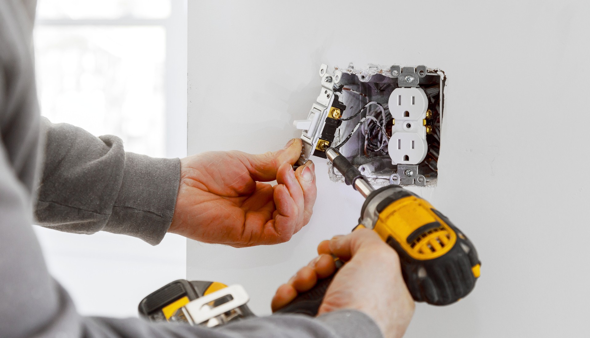 electrician working on electrical switch and wires